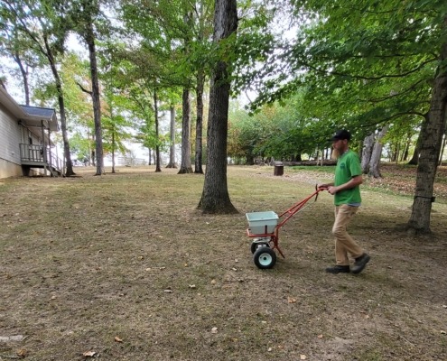 A member of The Galloway Team spreading grass seed in a Chattanooga yard.