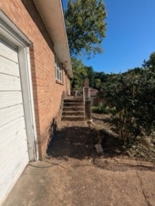 This image shows an entryway with overgrowth after brush removal.